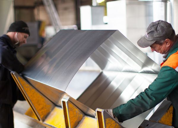 two men holding ductwork by dynamic metalworks inc.